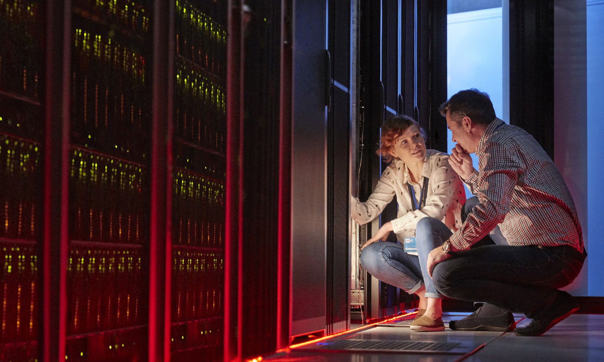 Two professionals working in a data center