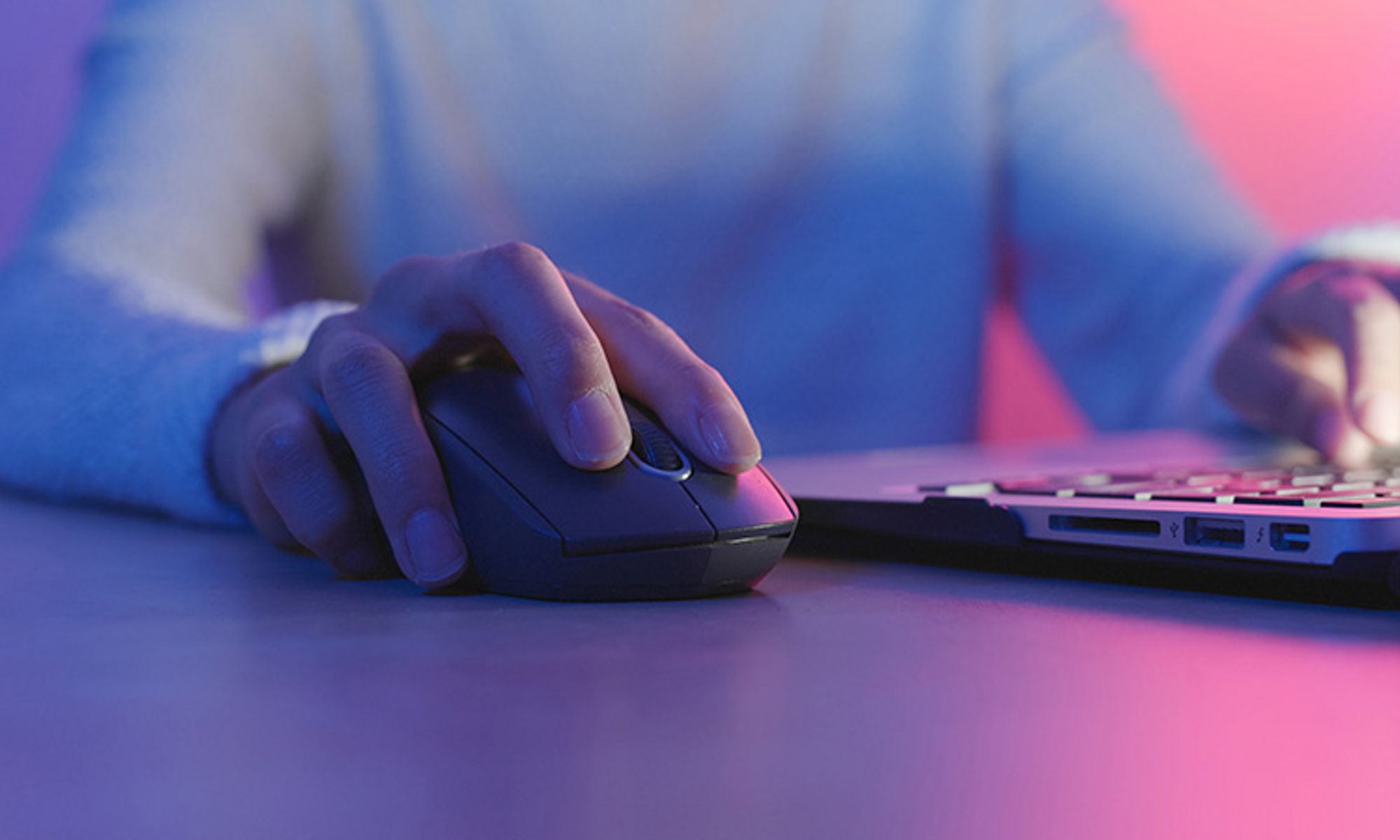 Woman using a mouse at a laptop