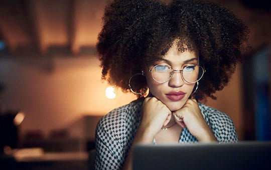 Woman reads blog on laptop.